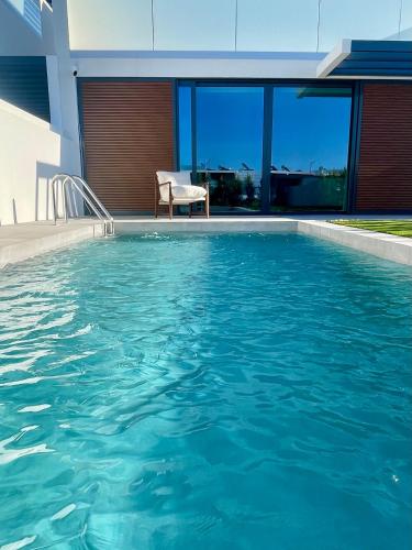 a swimming pool in front of a house at Lux Hiato's Villa in Luz de Tavira