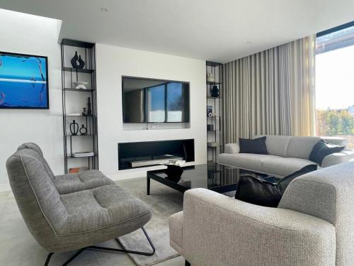 a living room with a couch and a tv at Lux Hiato's Villa in Luz de Tavira