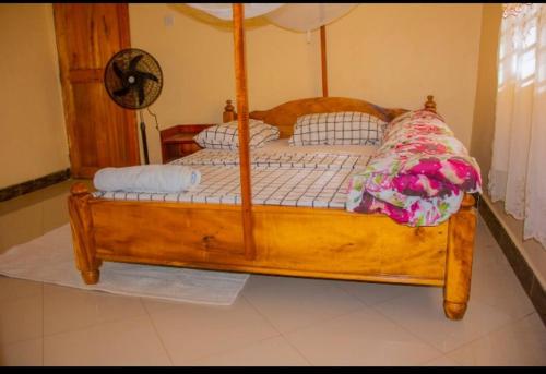a wooden bed with a wooden frame in a room at Mama Maya peaceful home in Moshi