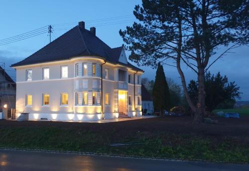 a large white house with lights on it at night at Villa Romantika in Ichenhausen