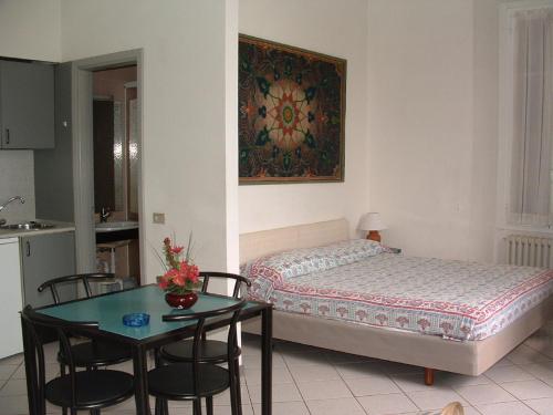 Holiday Residence في بافينو: غرفة نوم بسرير وطاولة مع كراسي