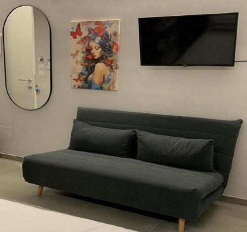 a couch sitting in a living room with a mirror at Casa Armonia Apartment Sulmona in Sulmona