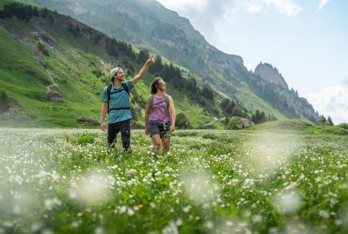 a man and woman walking through a field of flowers at L’Aiglon Grand studio familial in Champagny-en-Vanoise