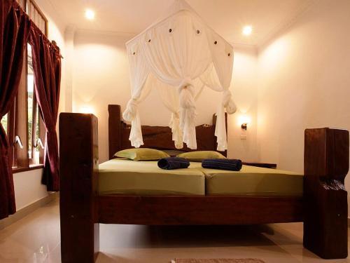 a bedroom with a bed with a drape on it at Indra Valley Inn Bukit Lawang in Bukit Lawang