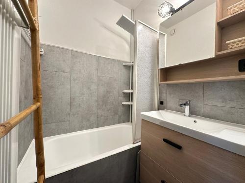 a bathroom with a sink and a bath tub at L’Aiglon Grand studio familial in Champagny-en-Vanoise