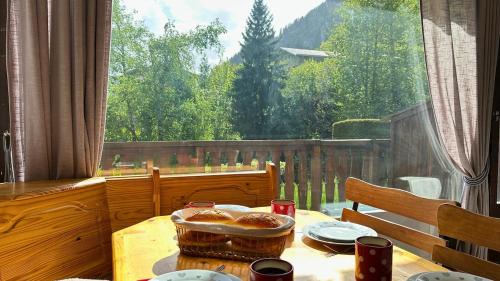 a table with a plate of food and a window at L’Aiglon Grand studio familial in Champagny-en-Vanoise