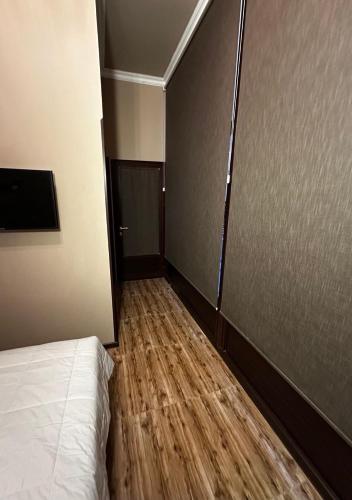 a small room with a bed and a wooden floor at CA Yerevan Hotel in Yerevan