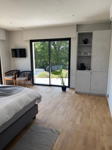 a bedroom with a bed and a large sliding glass door at B and B 46 in Tour-de-Faure