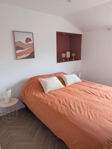 - une chambre avec un lit avec des draps orange et une table dans l'établissement Sirius 3 - Superbe appartement centre ville pour 4 Personnes, au Mans