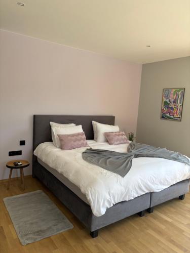 a bedroom with a large bed with pink pillows at B and B 46 in Tour-de-Faure