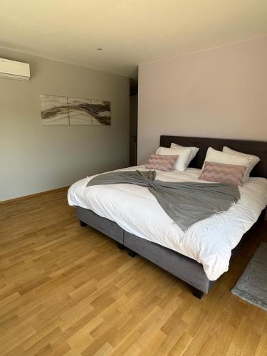 a bedroom with a bed with white sheets and pink pillows at B and B 46 in Tour-de-Faure