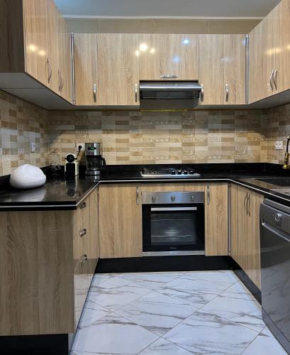 a kitchen with wooden cabinets and a stove top oven at Nara luxe 3 Berkane in Berkawe