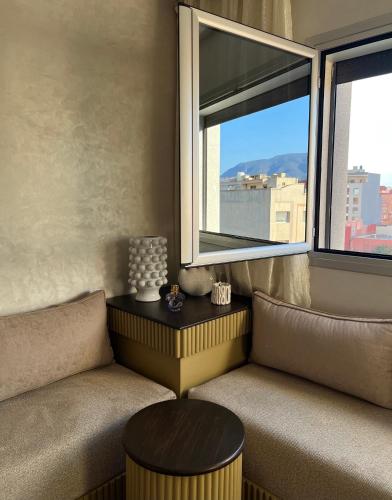 a room with two chairs and a table and two windows at Nara luxe 3 Berkane in Berkawe