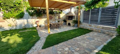 a patio with a table and chairs under a pergola at Villa kontes kefalonia in Kardhakáta