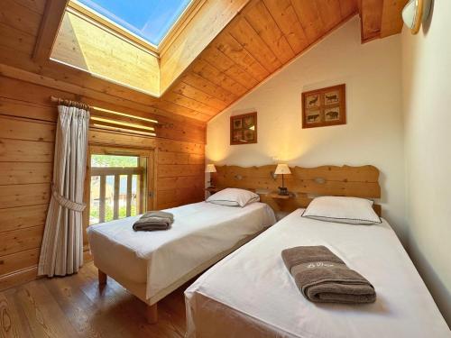 - 2 lits dans une chambre avec une lucarne dans l'établissement Mira, Vue Exceptionnelle confort piscine, Spa, à Champagny-en-Vanoise