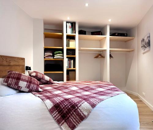 une chambre avec un lit avec une couverture à carreaux dans l'établissement Serac Appartement au coeur de la vanoise, à Champagny-en-Vanoise