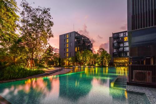 una piscina in una città al tramonto di The Deck Condominium by Lofty a Patong Beach
