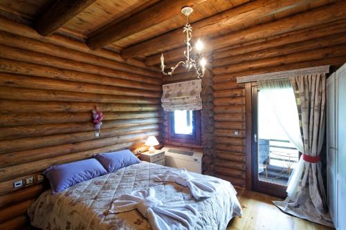 a bedroom with a bed in a log cabin at Yliessa Chalet in Domnista