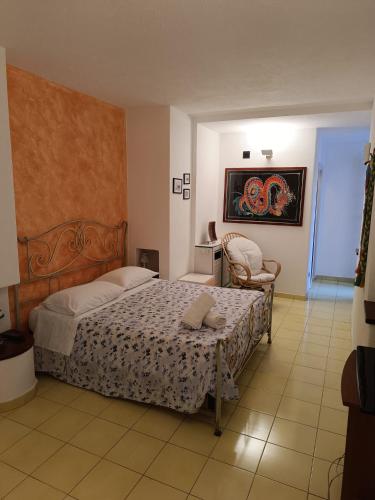 a bedroom with a bed and a chair in it at Villa Calù in Casamicciola Terme