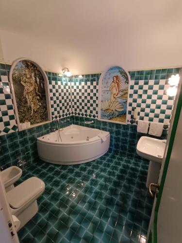 a bathroom with a tub and a tiled floor at Villa Calù in Casamicciola Terme