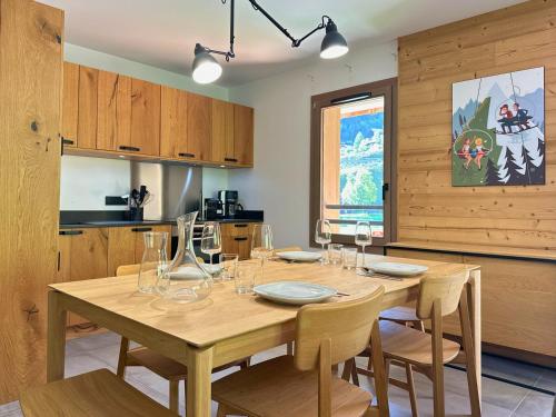 a dining room with a wooden table and chairs at Sources, Terrasse et confort 4 étoiles in Champagny-en-Vanoise