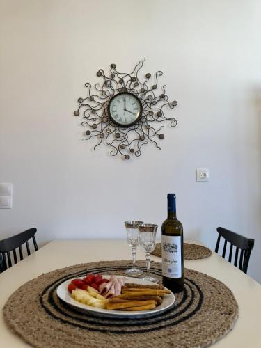 a table with a plate of food and a bottle of wine at white house apollon naxos in Apollon