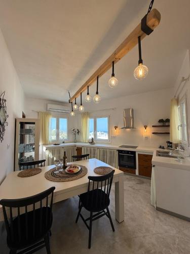 a large kitchen with a table and chairs in it at white house apollon naxos in Apollon