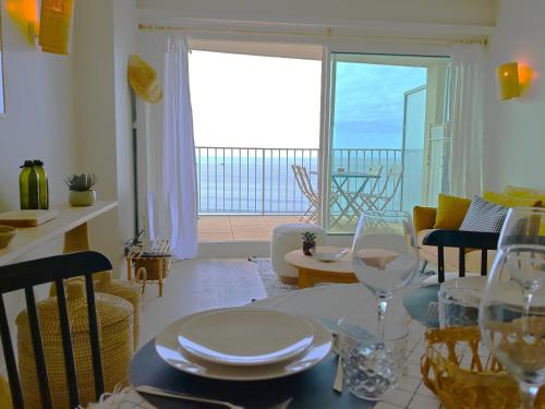 - un salon avec une table et des verres à vin dans l'établissement LE SUNSET - Face Mer, à Les Sables-dʼOlonne