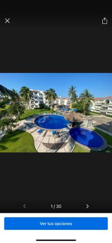 a television screen with a picture of two blue pools at Departamento en suites palmas, con club de playa in Manzanillo