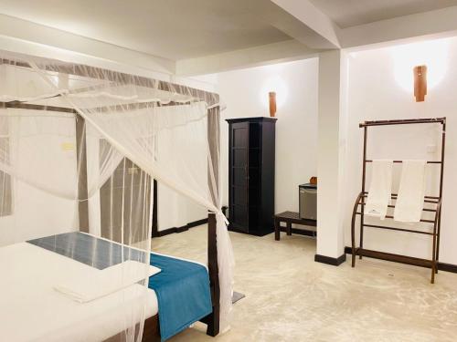 a bedroom with a canopy bed and a mirror at Ahangama Eco Villa in Ahangama