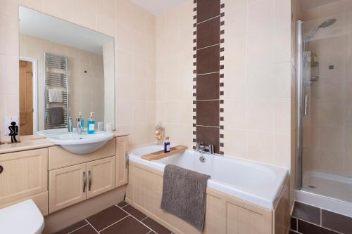a bathroom with a tub and a sink and a shower at 4-Bed House sleeps 8 Groups & Work Stays in Penrith