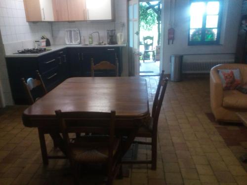 - une cuisine avec une table et des chaises en bois dans la chambre dans l'établissement echte plattelandservaring in rust en ruimte, à Serrigny-en-Bresse