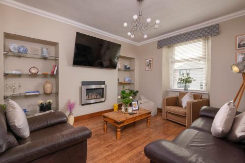 a living room with two couches and a table at 4-Bed House sleeps 8 Groups & Work Stays in Penrith