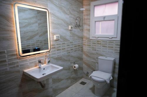 a bathroom with a sink and a toilet and a mirror at The Expert in Ocean Blue Near Airport in Cairo