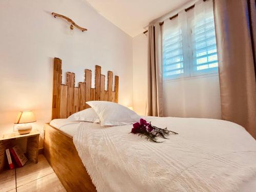 a bedroom with a white bed with flowers on it at Appartement Cosy La Vanille 1 in Ducos