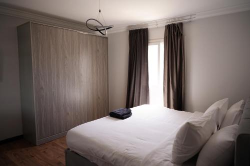 a bedroom with a large white bed and a window at The Expert in Ocean Blue Near Airport in Cairo