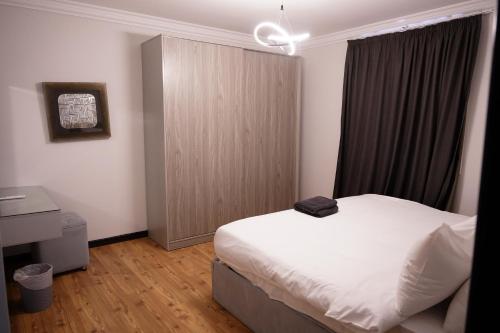 a bedroom with a white bed and a window at The Expert in Ocean Blue Near Airport in Cairo