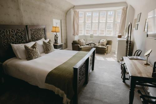 a bedroom with a large bed and a living room at The Bull And Swan in Stamford