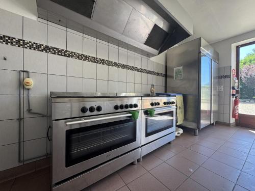 une cuisine avec une cuisinière en acier inoxydable et une fenêtre dans l'établissement L Endurance 24h - 15pers - Circuit Bugatti - Rêve au Mans, à Teloché