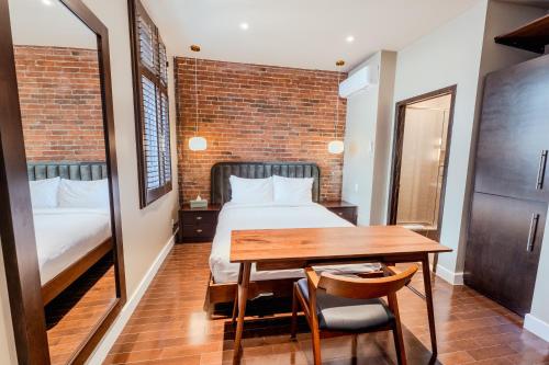 a bedroom with a bed and a desk and a table at Self Check-In Boutique Hotel - Quartier latin - Room 202 in Montréal