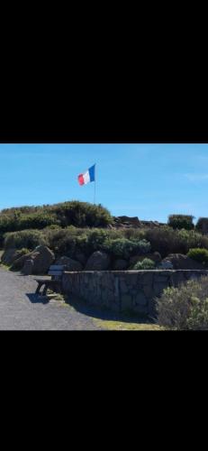 un drapeau flottant dans le ciel au-dessus d'un mur de pierre dans l'établissement Appartement Cap D'agde 100 m de la mer, au Cap d'Agde