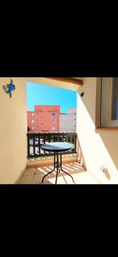 une table sur le balcon d'un bâtiment dans l'établissement Appartement Cap D'agde 100 m de la mer, au Cap d'Agde