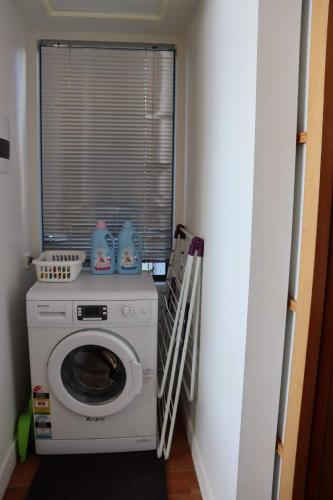 a laundry room with a washing machine and a window at The Tamar Ridge Lookout 2BR 2Bath Suite in Grindelwald