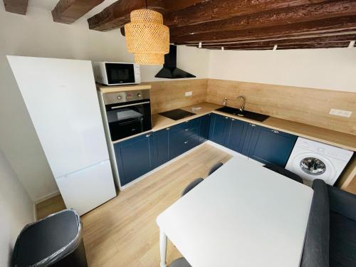 une petite cuisine avec des armoires bleues et une table blanche dans l'établissement Duplex Beauvoisine - 387, à Rouen