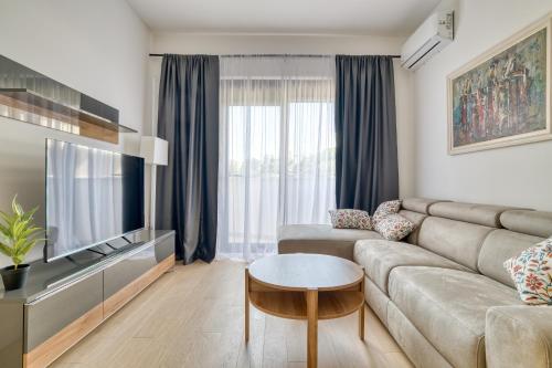 a living room with a couch and a tv at Twin Towers LT Luxury in Becici