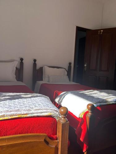 a bedroom with two beds with red and white blankets at Casa Augusta - QUINTA in Penafiel