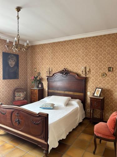 une chambre avec un grand lit et un lustre dans l'établissement Appartement lumineux Perpignan Sud - proches commodités, à Perpignan