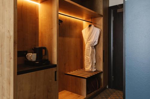 a closet with a robe hanging on a wooden wall at voco Belfast by IHG in Belfast