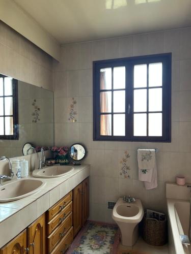 une salle de bain avec deux lavabos et un WC et une fenêtre dans l'établissement Appartement lumineux Perpignan Sud - proches commodités, à Perpignan