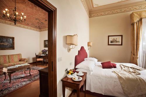 a bedroom with a bed and a couch and a table at Villa Poggiano in Montepulciano